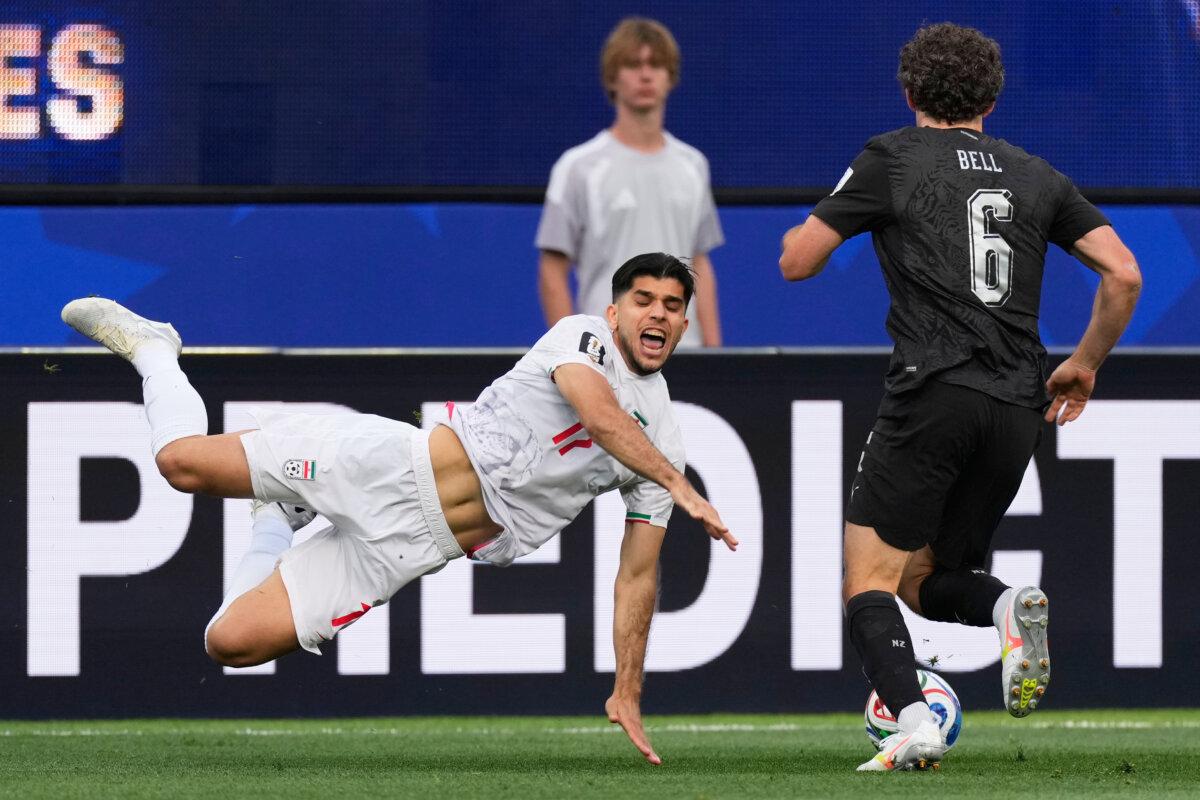 Iran's Arya Yousefi falls to the ground as New Zealand's Joe Bell challenges for the ball during the World Cup soccer match between the two countries in Inglewood, Calif., on June 15, 2026. (Mark J. Terrill/AP)