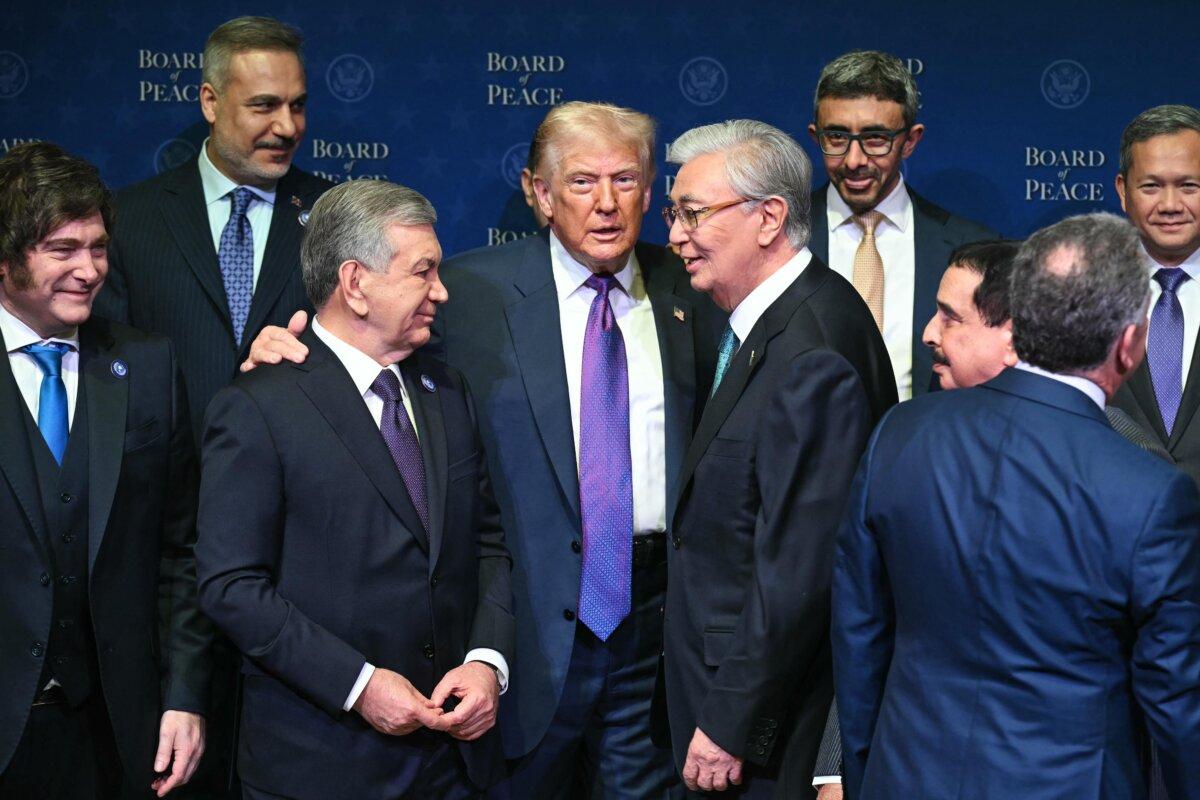 U.S. President Donald Trump (C), flanked by Kazakh President Kassym-Jomart Tokayev (R) and Uzbek President Shavkat Mirziyoyev (L), gathers with leaders during a group photo during the inaugural meeting of the Board of Peace at the U.S. Institute of Peace in Washington on Feb. 19, 2026. (Saul Loeb/AFP via Getty Images)