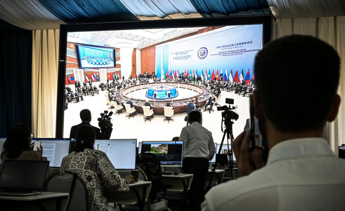 Journalists watch the live broadcast of the plenary session of the Shanghai Cooperation Organization summit in Samarkand, Uzbekistan, on Sept. 16, 2022. (Alexander Nemenov/AFP via Getty Images)