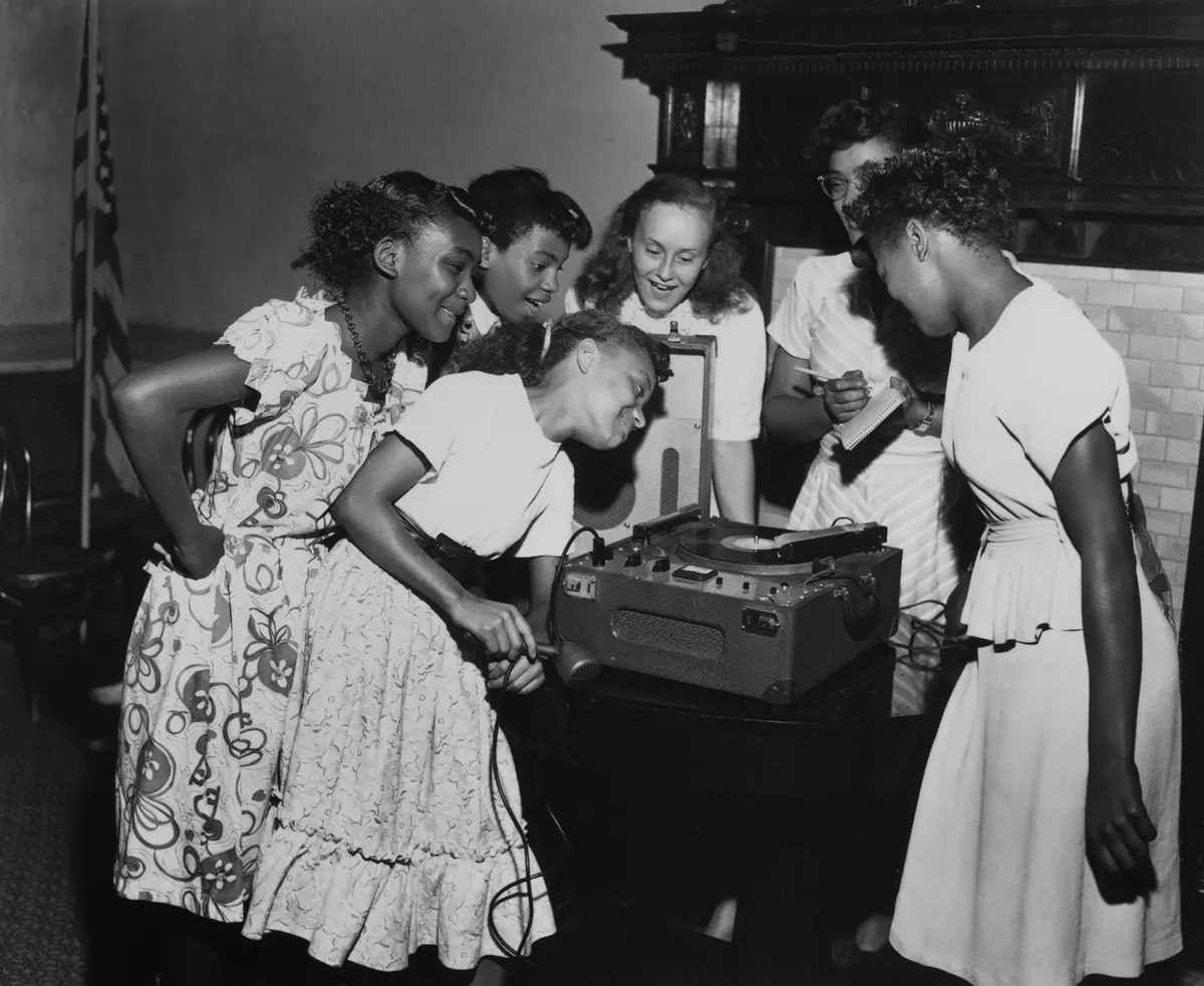 Schoolgirls listen to a recording of their voices played on a record player at the National Urban League's Charm School in Brooklyn, New York, 1948. (FPG/Archive Photos/Getty Images)