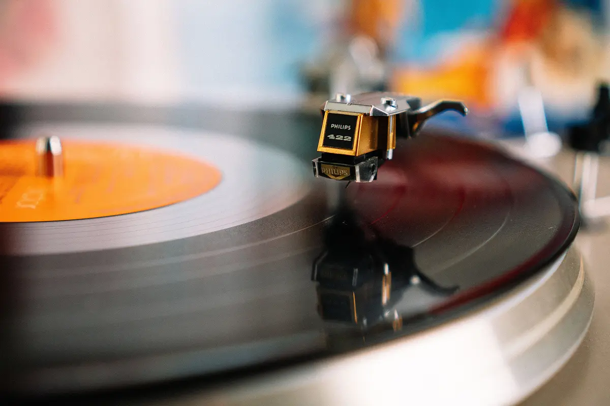 A record player produces sound by tracing microscopic grooves in the vinyl with a stylus, converting physical vibrations into music. (Matthias Groeneveld/Pexels)