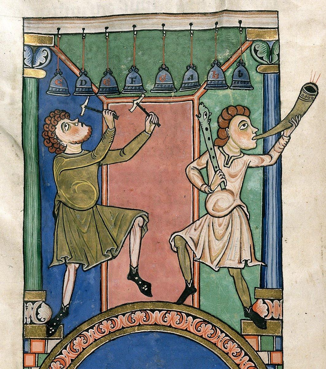An illustrated folio of two musicians playing medieval musical instruments from Worms Bible, A.D. 1025–1075. The musician on the left is playing chime bells, while the other musician is blowing the horn and holding a cornett with a carved animal head. (Public Domain)
