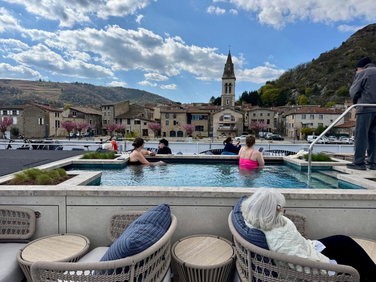 A couple of passengers soak in the ship's pool while soaking up views of Andance, a pretty village on the Rhone. (Lori Rackl/TNS)