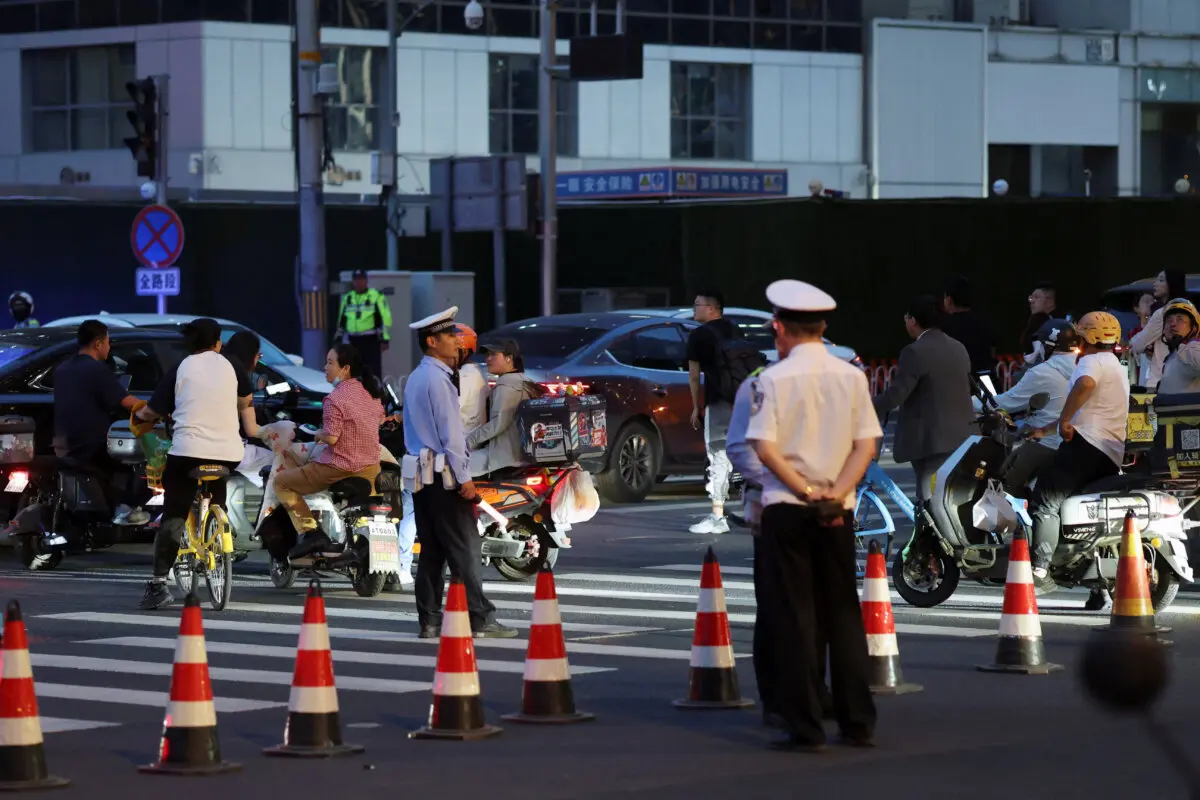 Police officers keep watch at a junction near CITIC Tower, also known as China Zun, where damage is visible on a high floor of the exterior, in Beijing, China, June 26, 2026. (Maxim Shemetov/Reuters)