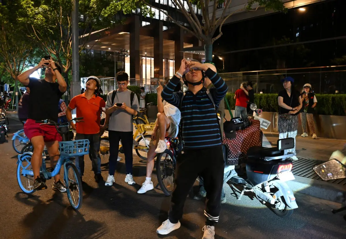 People take photographs of the CITIC Tower in Beijing on June 26, 2026. (Adek Berry/AFP via Getty Images)