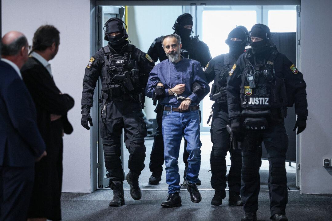 Judicial officers escort Saudi Arabian defendant Taleb Al Abdulmohsen (C) to the courtroom upon his arrival on June 26, 2026 in Magdeburg, eastern Germany, before his trial for driving an SUV through a crowd at a Christmas market. The court sentenced to life in jail the Saudi psychiatrist who drove an SUV through a crowded Christmas market in 2024, killing six people and injuring more than 300. (Photo by Ronny HARTMANN / AFP via Getty Images)