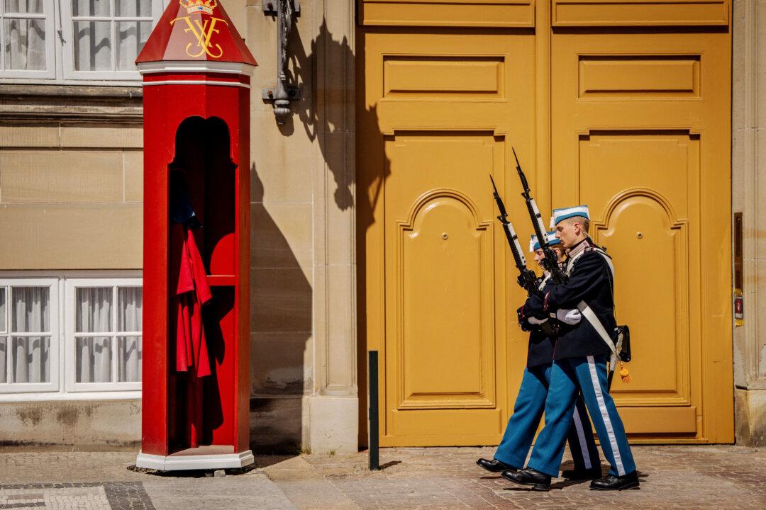 Guards, having taken off their bearskin hats, patrol during a heatwave in front of Amalienborg Palace in central Copenhagen on June 26, 2026. Europe's heatwave has smashed several temperature records, the UN's weather and climate agency said on June 26, adding that it would determine the full impact once the phenomenon has ended. The heatwave has pushed up temperatures even in usually milder northern countries such as Denmark. According to the Danish Meteorological Institute, the definition of a heatwave is that the average of the highest temperatures over three consecutive days exceeds 28 degrees. (Photo by Mads Claus Rasmussen / Ritzau Scanpix / AFP via Getty Images) / Denmark OUT
