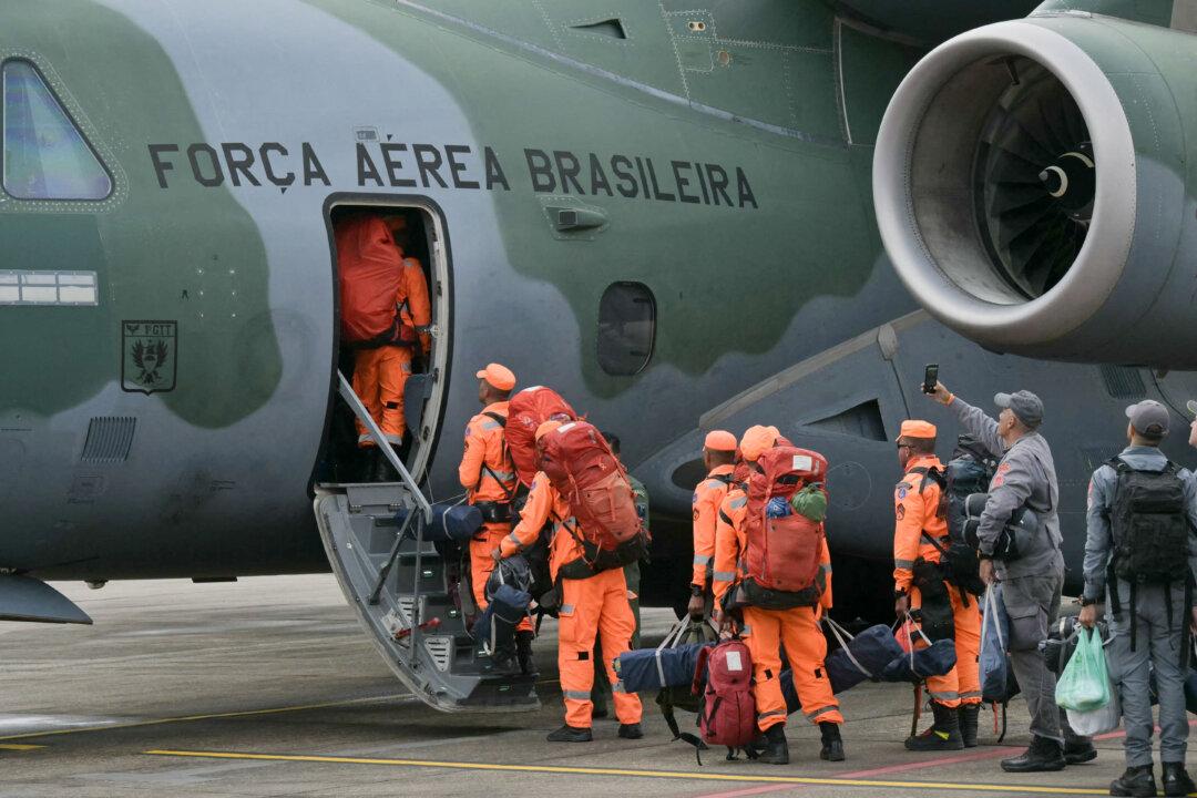 Brazilian firefighters, military personnel, and telecommunication technicians board a Brazilian Air Force plane for a humanitarian aid mission to Venezuela following deadly earthquakes, at Guarulhos air base in Guarulhos, Sao Paulo state, Brazil, on June 26, 2026. Using heavy equipment or their bare hands, rescuers and volunteers searched for survivors of the twin earthquake in Venezuela, which has officially left 589 dead and, according to estimates, thousands missing. (Photo by NELSON ALMEIDA / AFP via Getty Images)