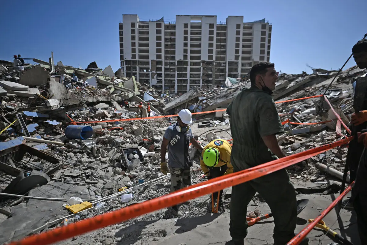 Rescue workers and volunteers look for missing people amid the rubble at Los Cocos beach, in Caraballeda, La Guaira state, Venezuela, on July 1, 2026. (Juan Barreto / AFP via Getty Images)