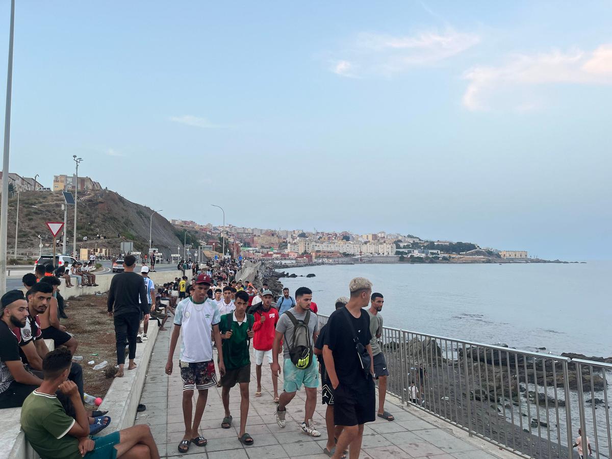 Moroccan migrants walk along Avenida Martínez Catena in Ceuta toward the border area on July 31, 2026, at 9:34 p.m. local time. (Etienne Fauchaire/The Epoch Times)