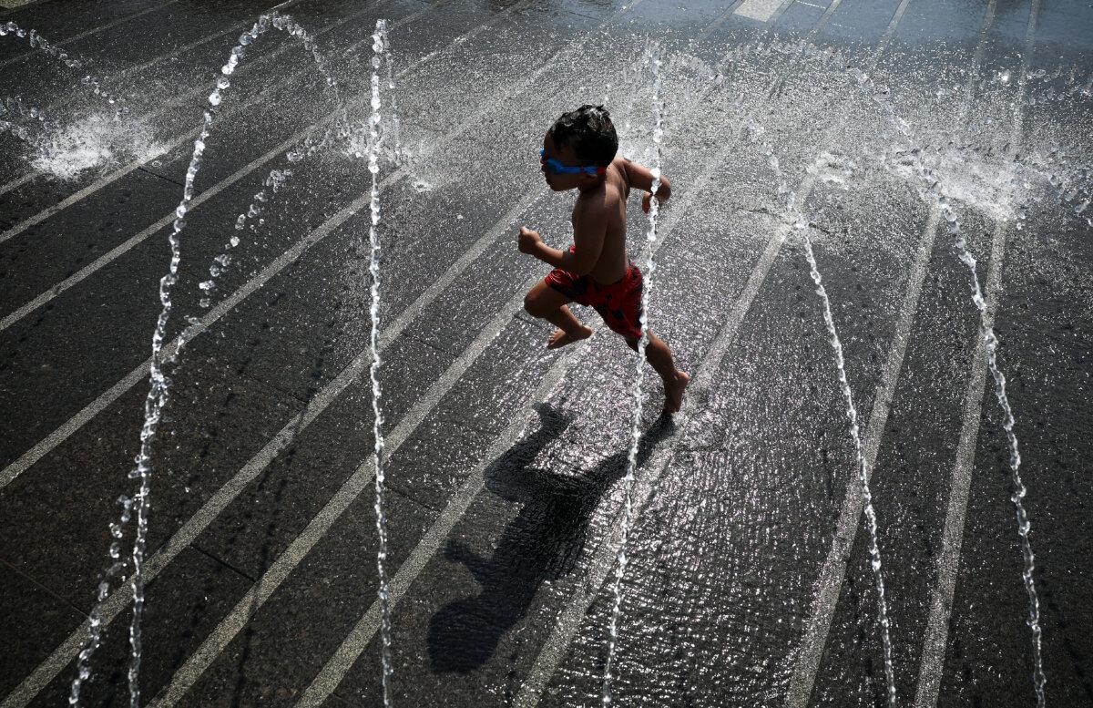 A child cools off in a fountain at Georgetown Waterfront Park in Washington on July 2, 2026. (Kevin Dietsch/Getty Images)