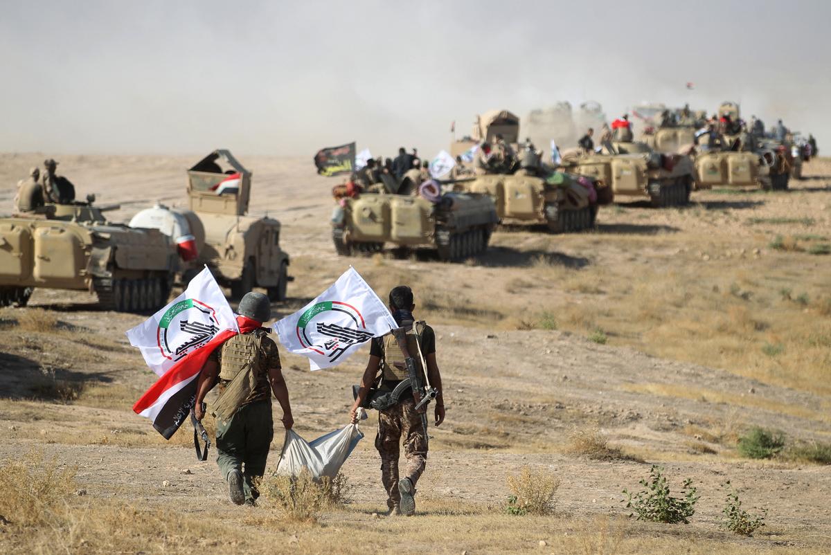 Fighters from the Hashed Al-Shaabi (Popular Mobilization units) advance toward the town of Tal Afar, west of Mosul, after the Iraqi government announced the beginning of the operation to retake it from the control of the Islamic State (IS) group on Aug. 22, 2017. (Ahmad Al-Rubaye/AFP via Getty Images)
