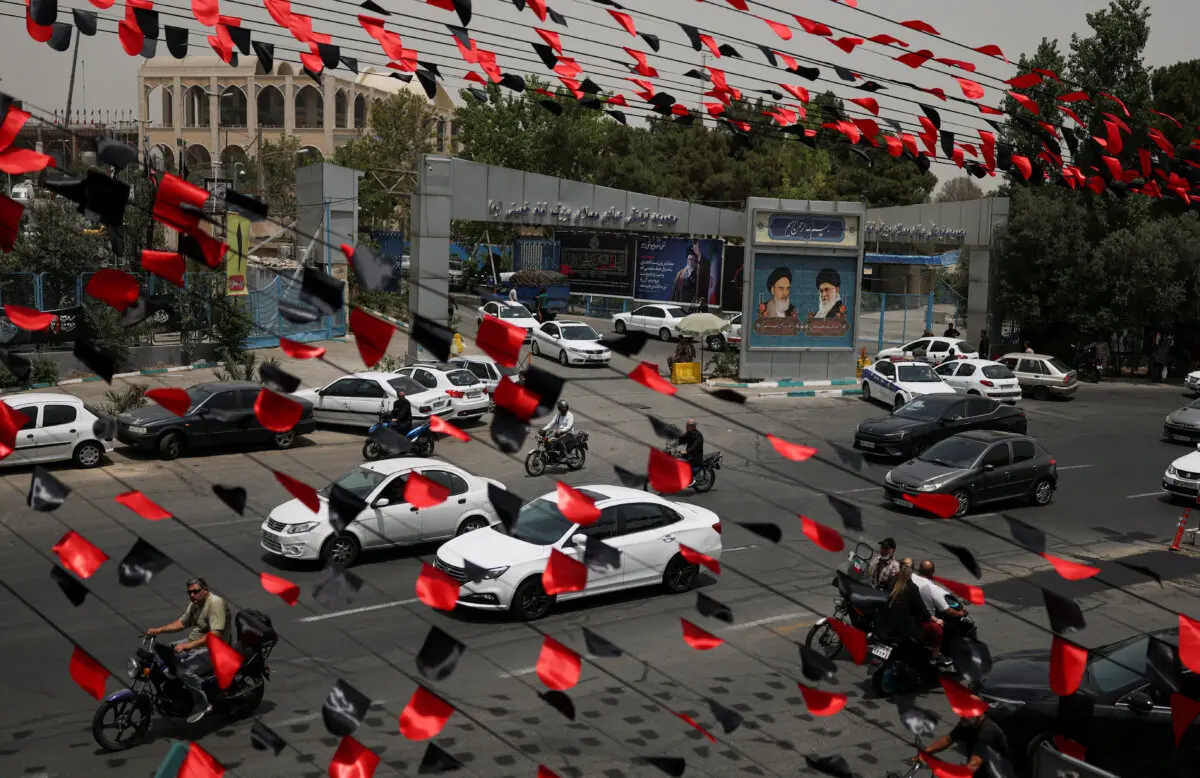 Red and black pennants hang above a street as vehicles pass by during preparations for a farewell ceremony for Iran's late Supreme Leader Ayatollah Ali Khamenei, who was killed on Feb. 28 in Israeli and U.S. airstrikes, outside the Imam Khomeini Mosalla, in Tehran, Iran, on July 2, 2026. (Mohammed Salem/Reuters)