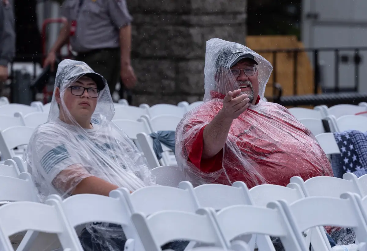 A family waits for the arrival of President Donald Trump in the rain at Mount Rushmore National Memorial in South Dakota on July 3, 2026. (John Fredricks/The Epoch Times)