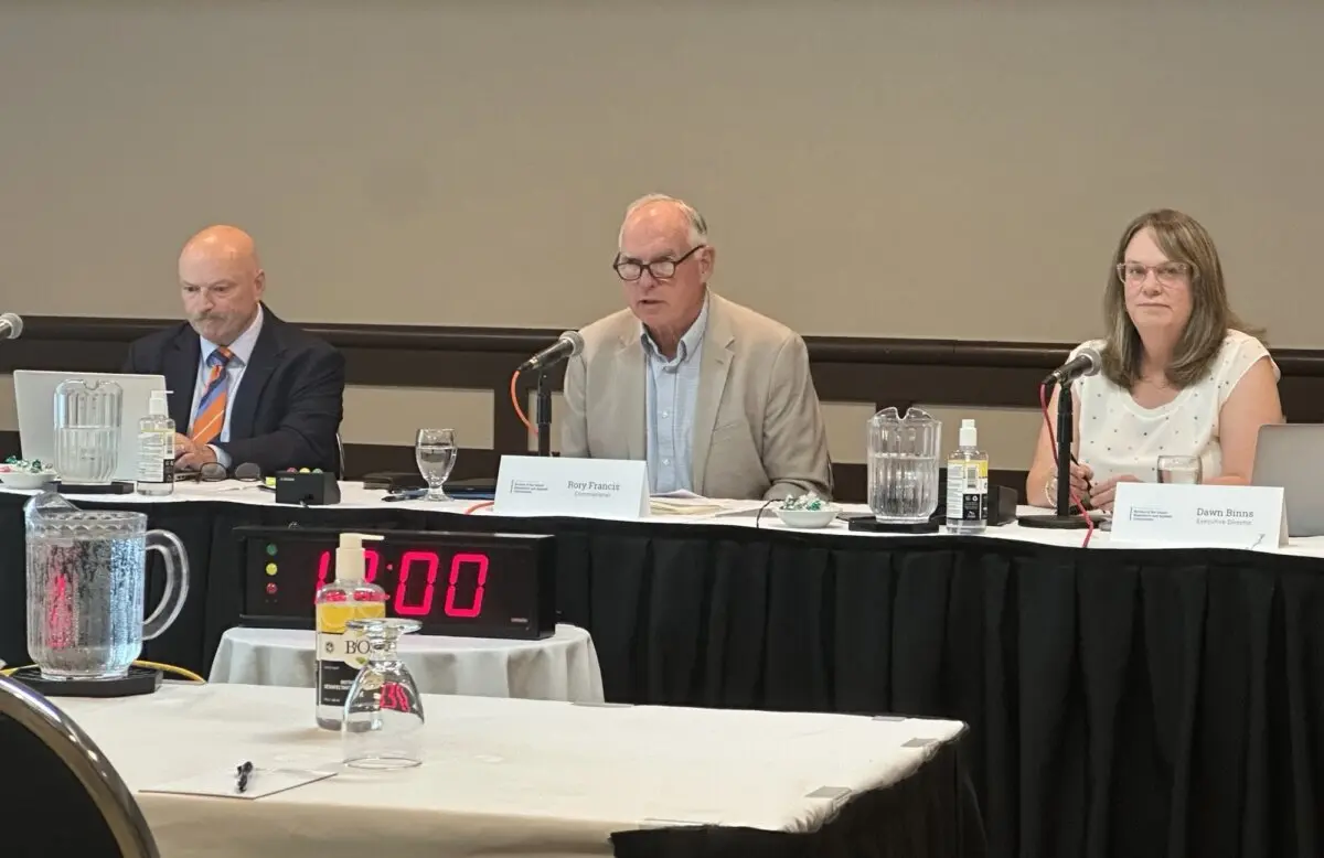 Commissioner Rory Francis (C) speaks at a public hearing of the Review of the Island Regulatory and Appeals Commission in Charlottetown on July 6, 2026. Also appearing on the panel are Kelly VanBuskirk (L), legal counsel for the commission, and Dawn Binns, executive director of the commission. (Omid Ghoreishi/The Epoch Times)