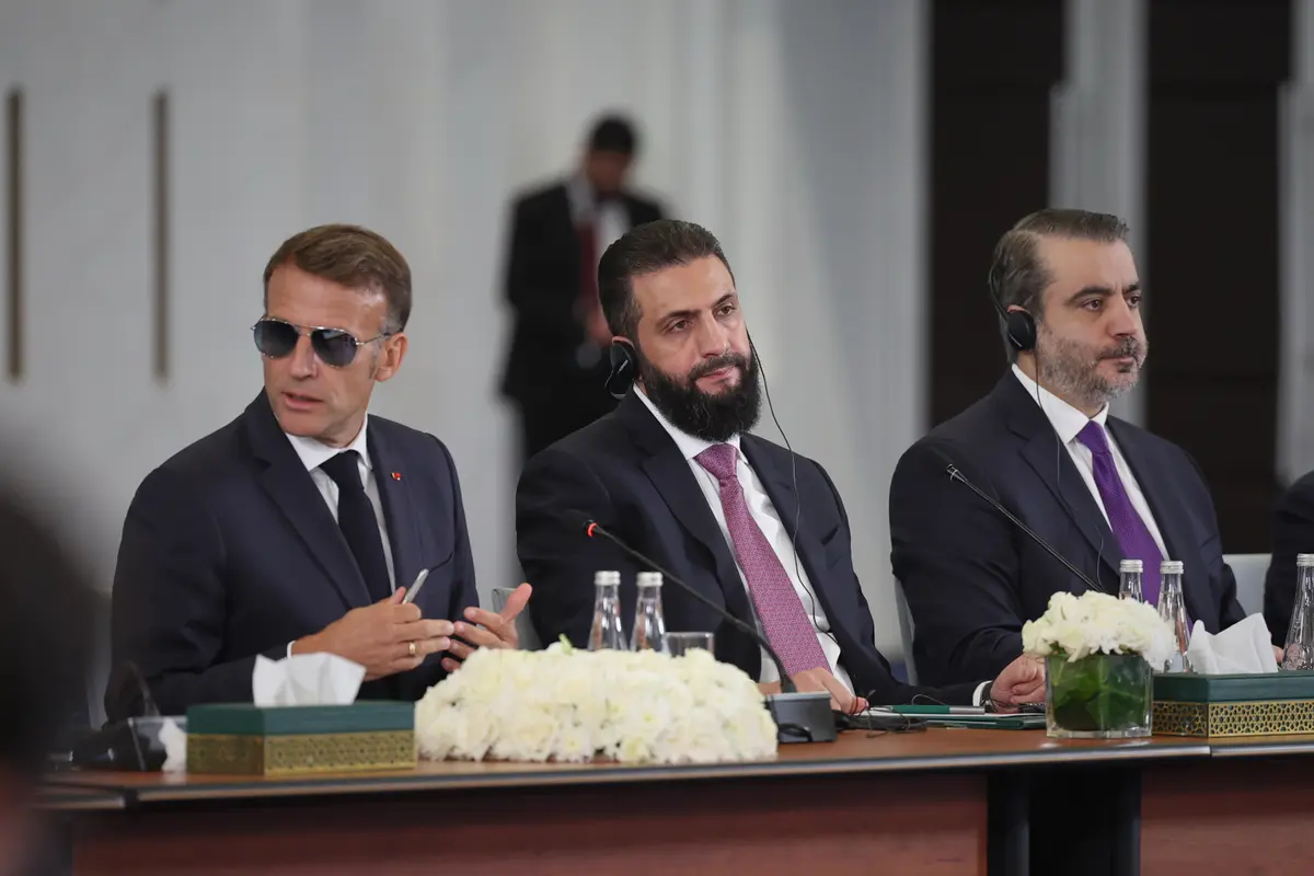 French President Emmanuel Macron (L), Syrian President Ahmad al-Sharaa (C), and Syrian Foreign Minister Asaad al-Shaibani (R) attend an event at the Economic Forum for Reconstruction in Damascus, Syria, on July 7, 2026. (Ghaith Alsayed/ AP Photo)