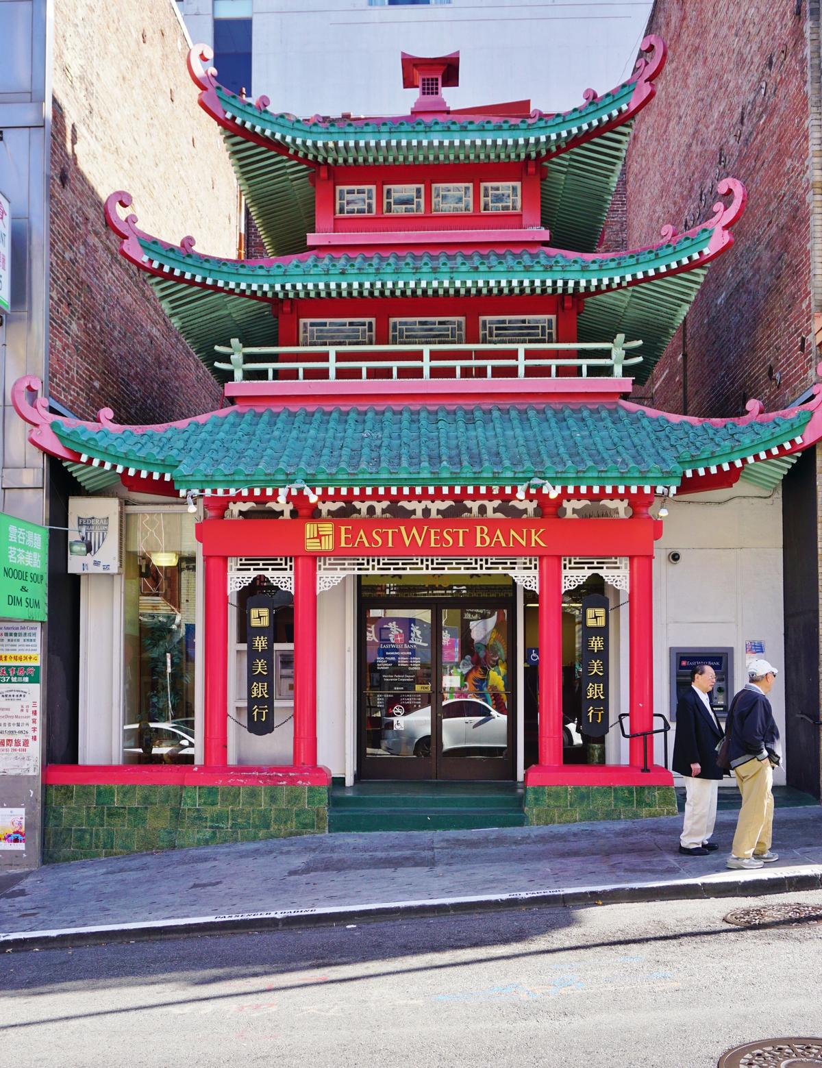 The East West Bank building on Washington Street and Grant Avenue is a notable example of Sino-American, or “Chinatown Baroque,” architecture blending Western structural methods with stylized Chinese design motifs. Its most distinctive features include a multi-tiered pagoda-style roofline and flared, upward-curving eaves that reflect an idealized interpretation of traditional Chinese architecture. (EQRoy/Shutterstock)