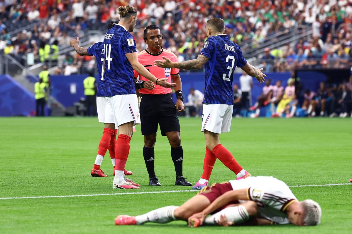 Salvadoran referee Ivan Barton speaks with France's midfielder #14 Adrien Rabiot (L) after he fouls Spain's forward #10 Dani Olmo during the 2026 World Cup football tournament semi-final match between France and Spain at the Dallas Stadium in Arlington on July 14, 2026. (Photo by Charly Triballeau/AFP via Getty Images)