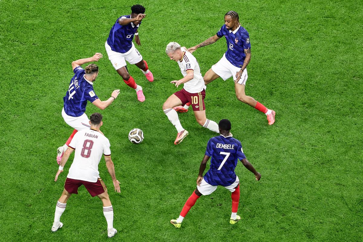 Spain's forward #10 Dani Olmo (C) is closed down by French players as he runs with the ball during the 2026 World Cup football tournament semifinal match between France and Spain at the Dallas Stadium on July 14, 2026. (Aric Becker / AFP via Getty Images)