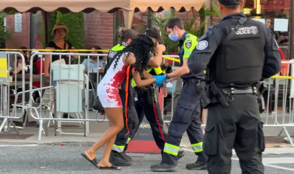 Police and paramedics tend to a person at a shooting at the Salsa on St. Clair event in Toronto, on July 11, 2026. (The Canadian Press/Jacob Estrin)