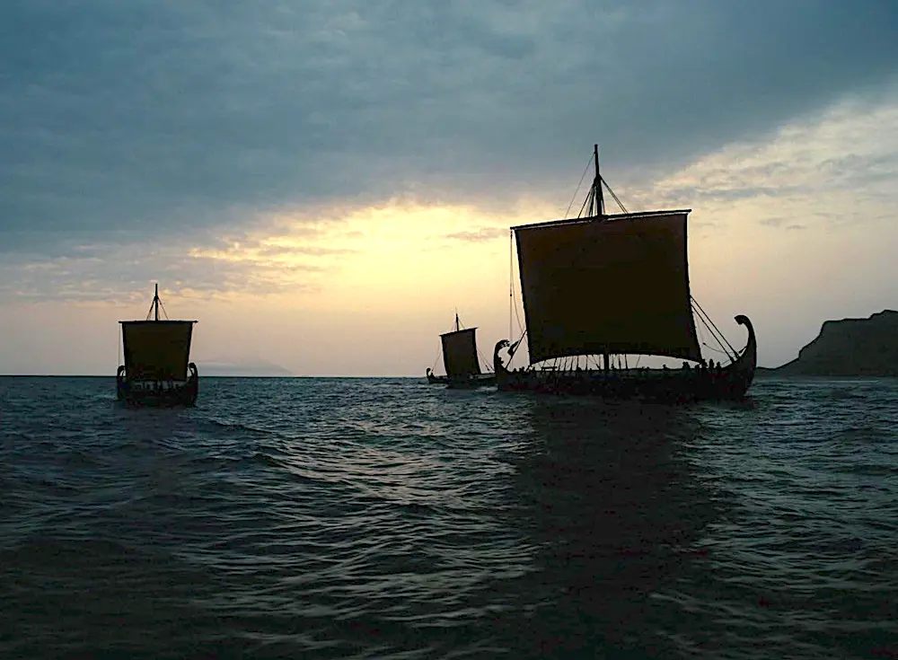 Odysseus's main ship and two smaller ships heading home, in "The Odyssey." (Universal Pictures)