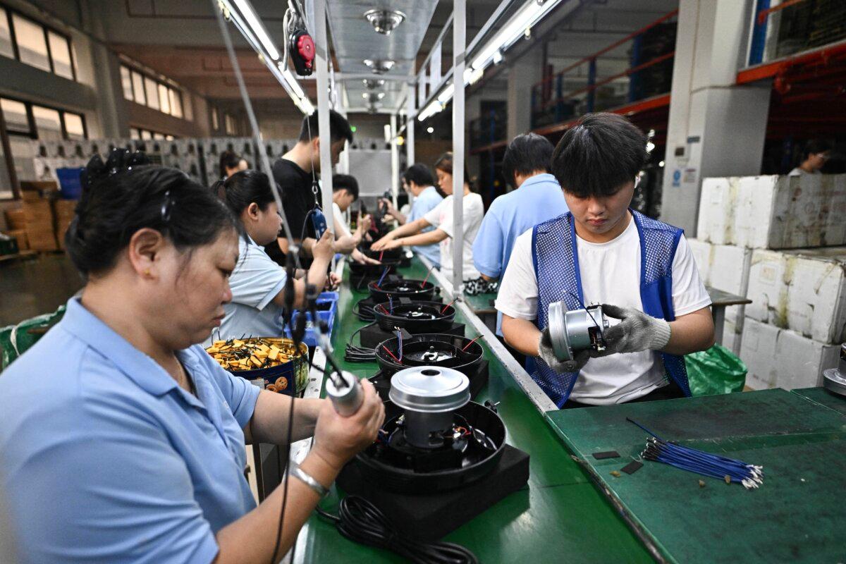 Employees working on the vacuum cleaner production line at a factory in Foshan, in southern Guangdong Province, China, on April 28, 2026. (Pedro Pardo/AFP via Getty Images)