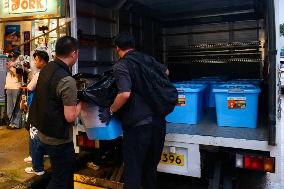 Police officers load confiscated items from an independent bookstore after the officers raided the "Have A Nice Stay" bookshop and arrested employees in Hong Kong on July 15, 2026. (Tommy Wang/ AFP via Getty Images)