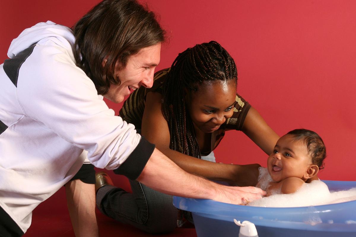 20-year-old soccer star Lionel Messi helps to bathe Lamine Yamal, who was merely six months old at the time with Yamal's mother Sheila Ebana during a photo session in the dressing room of the Camp Nou stadium in Barcelona, Spain, in September 2007. (Joan Monfort/AP Photo)