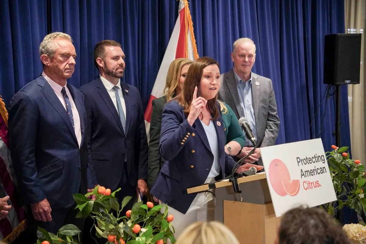 Sen. Ashley Moody (R-Fla.) speaks from the podium at a press conference where Human Services Secretary Robert F. Kennedy Jr. announced a Food and Drug Administration rule change for pasteurized orange juice sugar content in Lakeland, Fla., on July 17, 2026. Jacob Burg/The Epoch Times