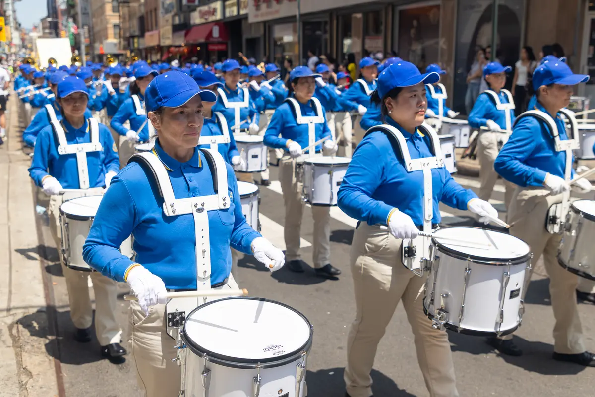 Falun Gong practitioners march during a parade calling for the end of the Chinese Communist Party’s 27 years of ongoing persecution against the spiritual practice, in New York City on July 19, 2026. (Mark Zou/The Epoch Times)
