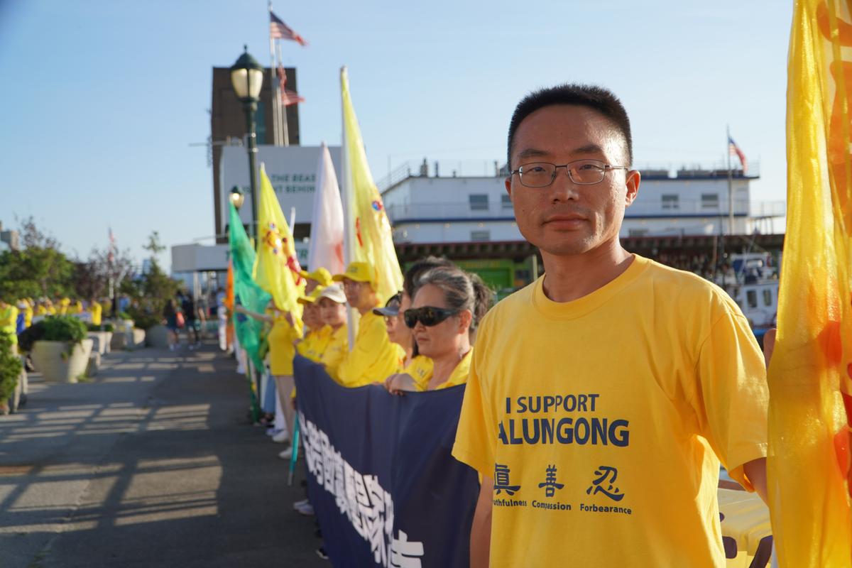 Liu Siyang holds a banner at the 2026 rally and vigil in New York City on July 20, marking 27 years since the Chinese Communist Party began its persecution of Falun Gong. (Nicholas Zifcak/The Epoch Times)