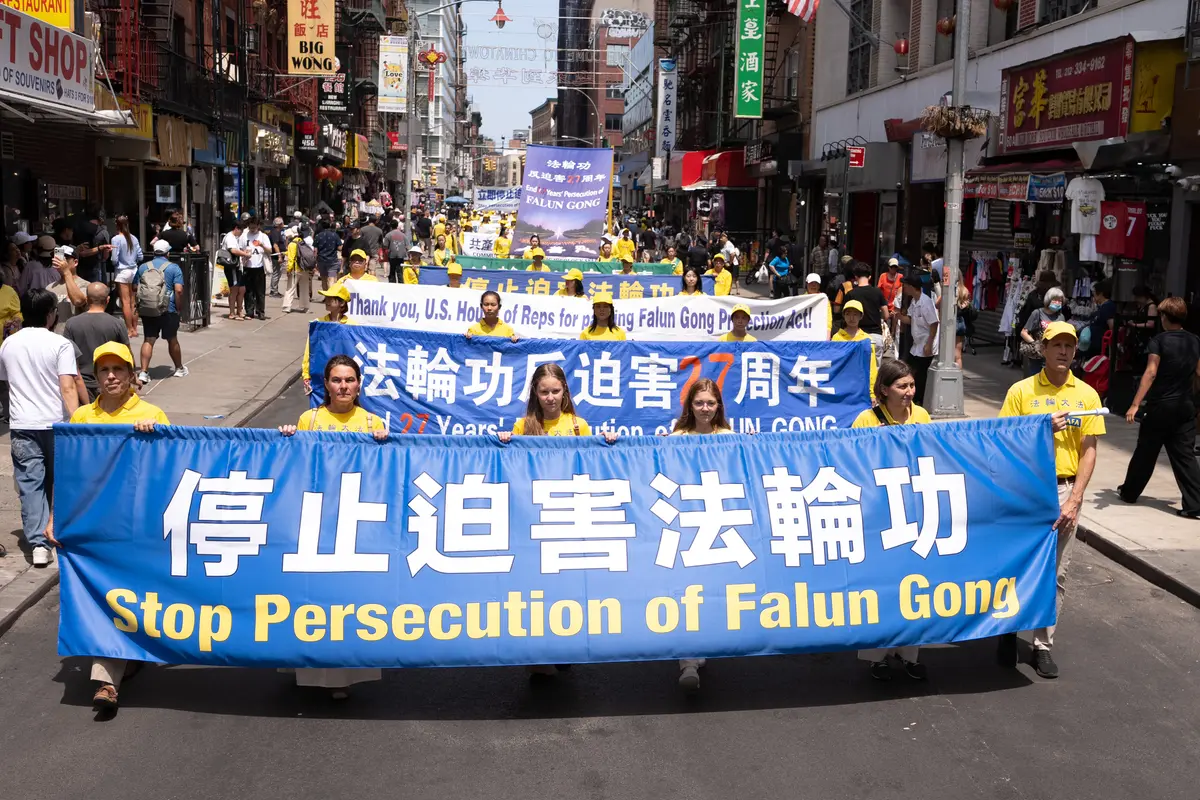 Falun Gong practitioners march during a parade calling for the end of the Chinese Communist Party’s 27 years of ongoing persecution against the spiritual practice, in New York City on July 19, 2026. (Larry Dye/The Epoch Times)