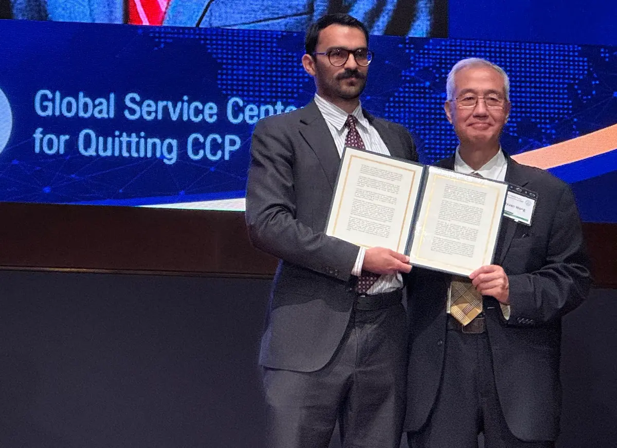 Christopher A. McNair (L), representing Rep. Andy Ogles (R-Tenn.), reads Ogles’s statement honoring the Tuidang movement and presents it to Zhiyuan Wang, president of the Global Service Center for Quitting the Chinese Communist Party, in Washington on July 21, 2026. (Nan Lin/The Epoch Times)