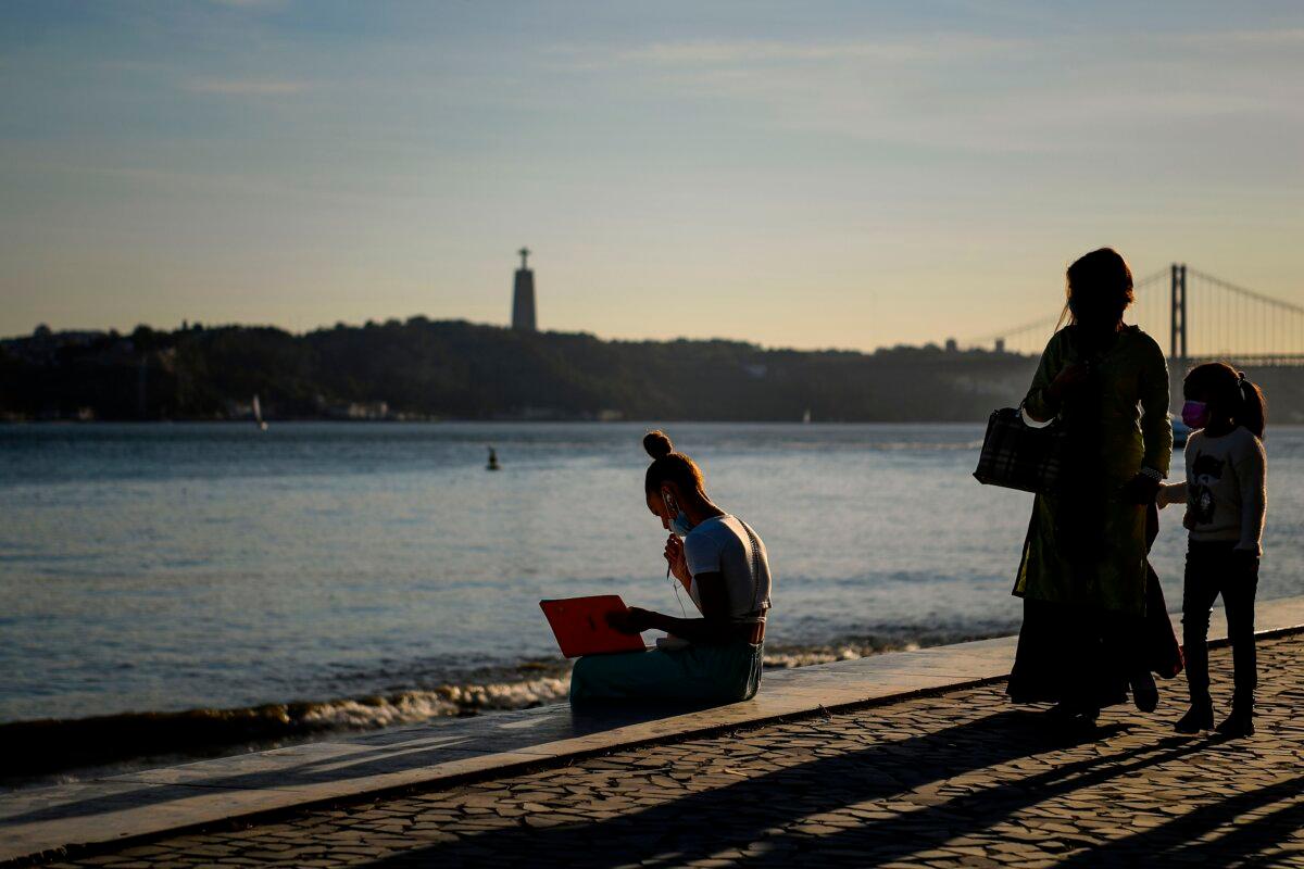 A woman reads a book at Ribeira das Naus in Lisbon, Portugal, in a file photo. (Patricia de Melo Moreira/AFP via Getty Images)