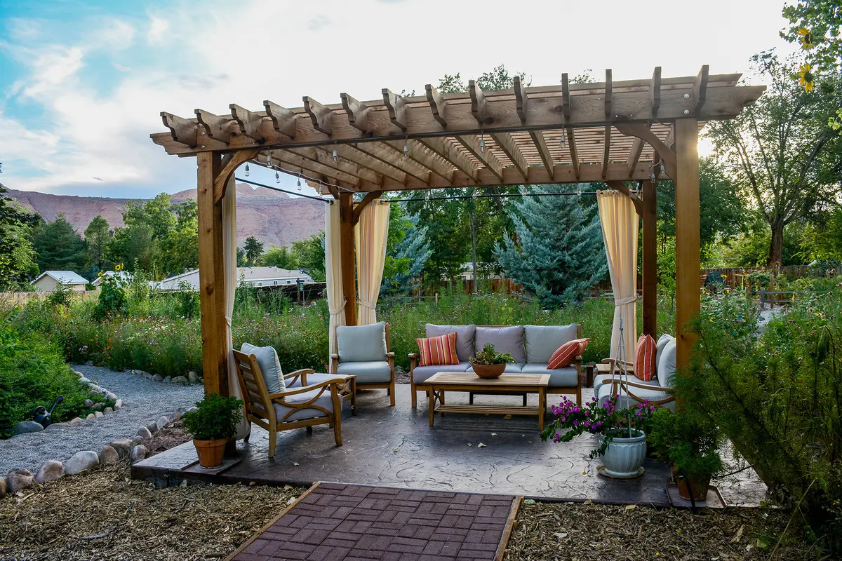 Freestanding pergolas offer flexibility because they can be positioned away from the home to define outdoor dining areas, gardens, or poolside retreats. (Blue Amber Design KC/Shutterstock)