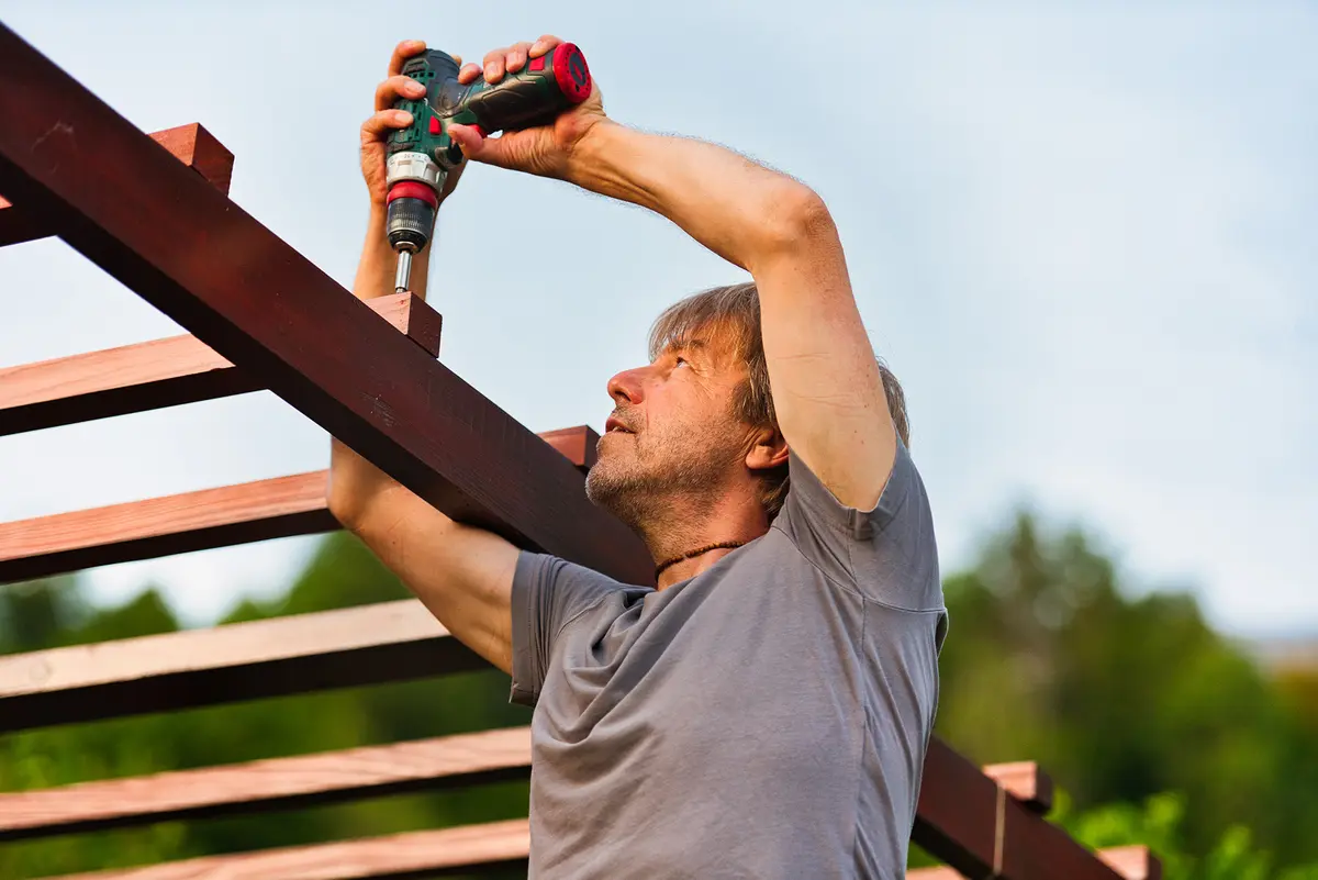 Many pergola kits are designed for homeowners with basic construction skills, although installation still requires careful measurements and attention to safety. (HMVart/Getty Images)