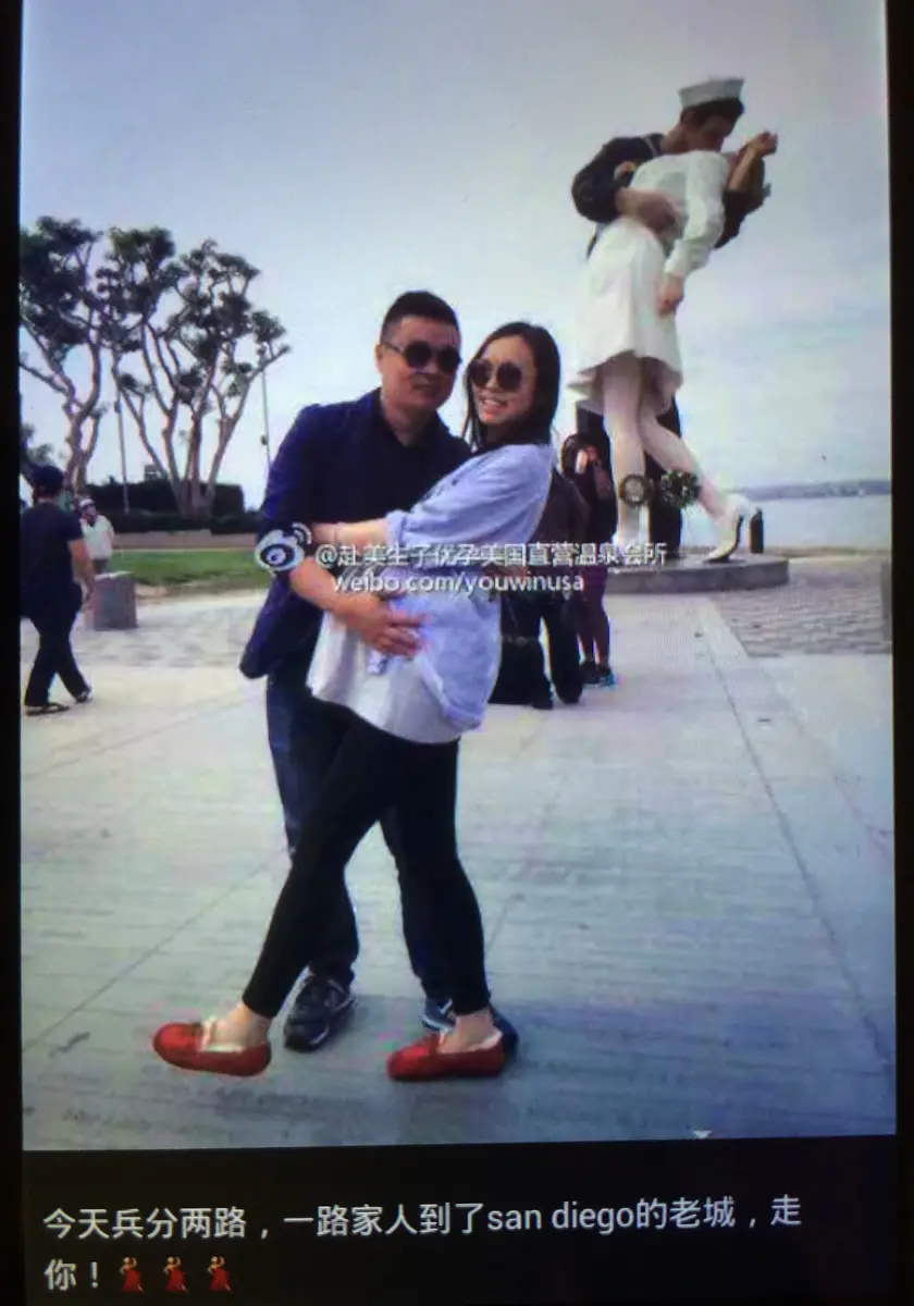 A man and a pregnant Chinese woman pose in front of a statue in a photo tagged "You Win." (Courtesy of U.S. Immigration and Customs Enforcement)