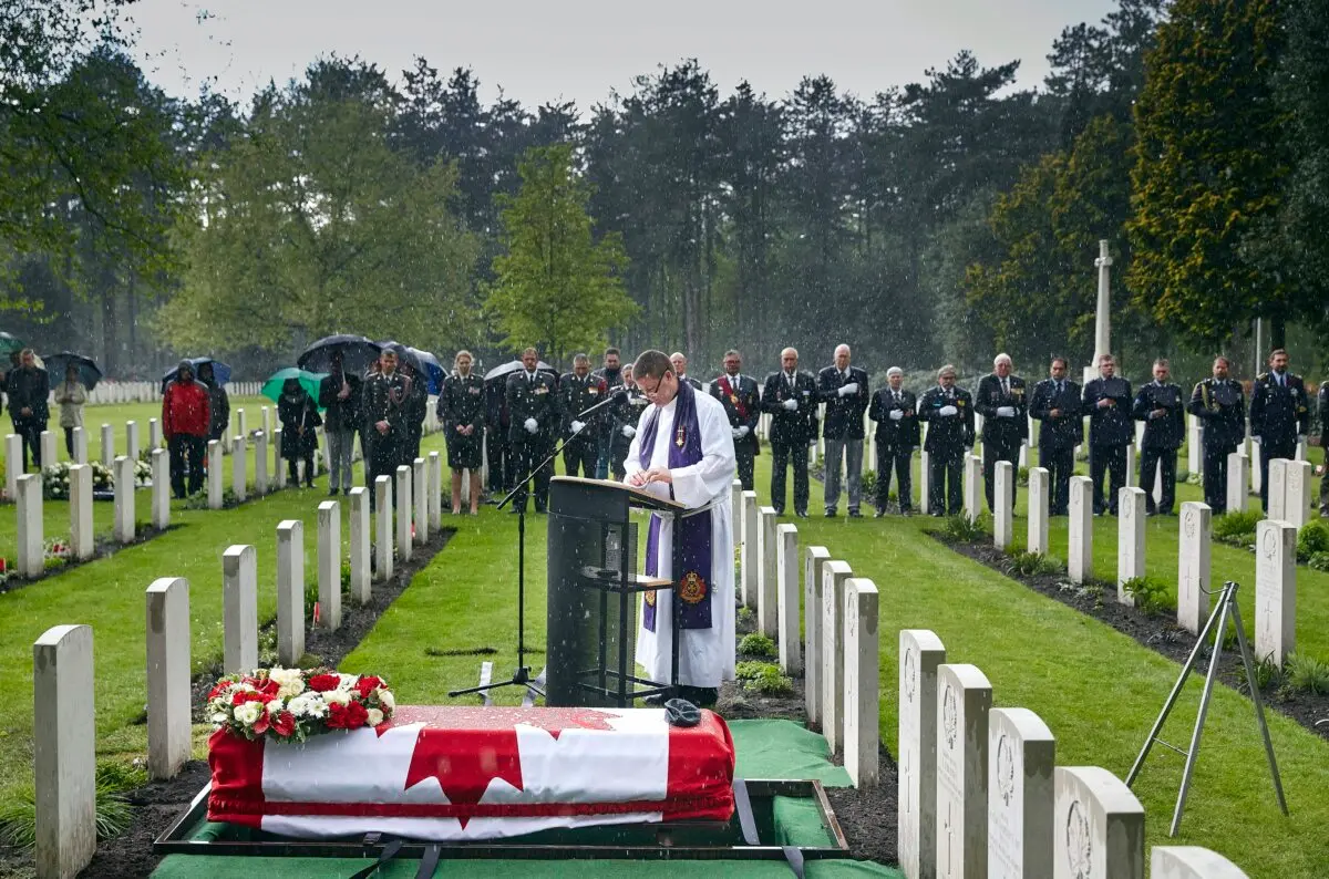 A padre says a prayer near a coffin bearing the remains of a Canadian soldier during a ceremony at the Canadian War Cemetery in Bergen op Zoom, Netherlands, on May 6, 2015. (AP Photo/Phil Nijhuis)