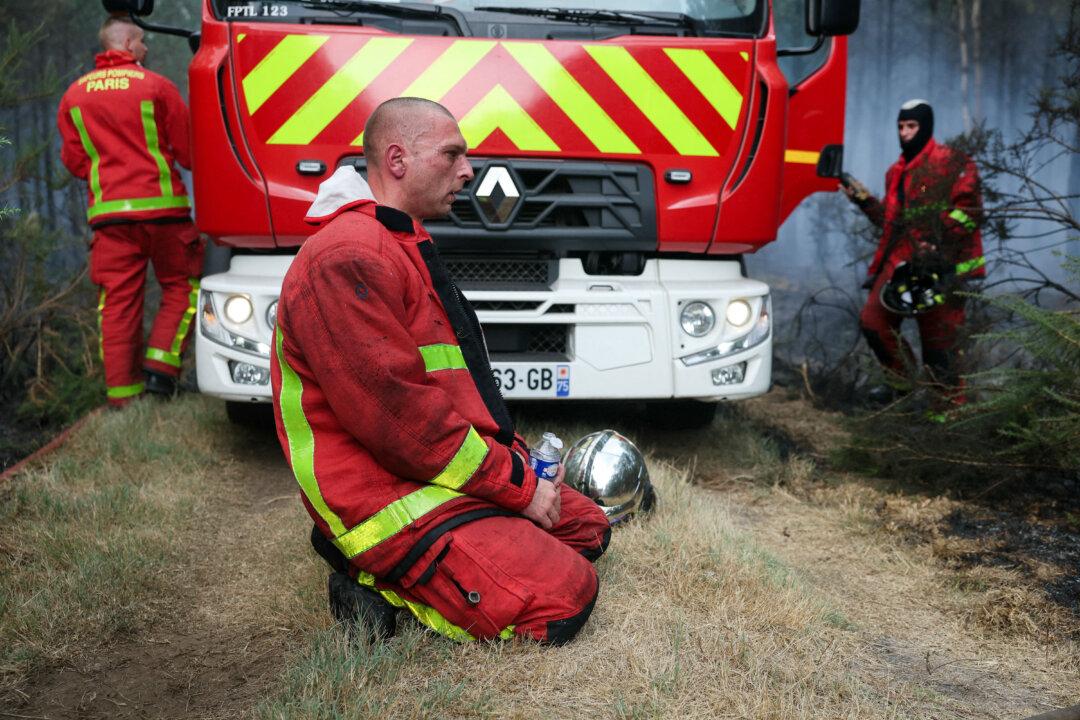 TOPSHOT - Firefighters of Paris Fire Brigade rest in Marcheprime west of Bordeaux on July 26, 2026 as a wildfire has been ravaging the forest north of the Arcachon Basin (Gironde) since July 22. The fire that has engulfed the area around the Arcachon Basin and is now threatening the outskirts of the Bordeaux metropolitan area has destroyed 42,000 hectares of "burned area," the Gironde prefecture announced; the prefecture has evacuated a total of 220,000 people since July 22. (Photo by ALAIN JOCARD / AFP via Getty Images)