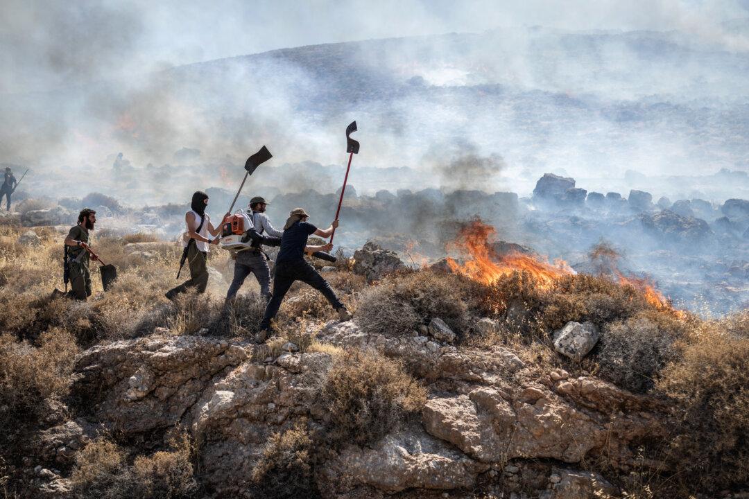 TOPSHOT - Israeli settlers try to extinguish a wildfire near the Ein Samiya spring in the Israeli-occupied West Bank on July 29, 2026. (Photo by ilia YEFIMOVICH / AFP via Getty Images)