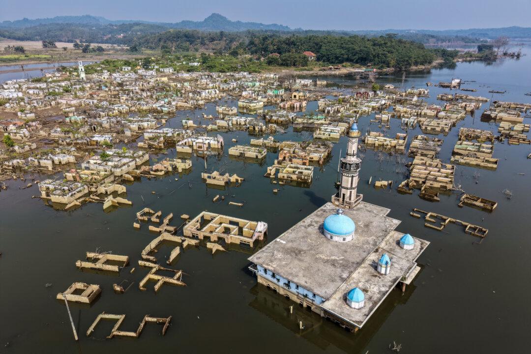TOPSHOT - An aerial view taken on July 30, 2026 shows a mosque and surrounding buildings in Somang village in Lebak in Indonesia's western Banten province, which was deliberately flooded to make way for the construction and filling of the Karian Dam that opened in 2023 and has now re-emerged due to the El Nino-driven drought. Somang village in the western Banten province of Indonesia's Java island has re-emerged from the water years after it was deliberately flooded to make way for the construction and filling of the Karian Dam, opened in 2023. As drought has taken hold of parts of Indonesia, the long-abandoned village has turned up years after its last residents were relocated, revealing the ruins of houses and a mosque. The Southeast Asian country is bracing for months of severe drought worsened by a particularly harsh El Nino, threatening water scarcity and food insecurity. (Photo by BAY ISMOYO / AFP via Getty Images)