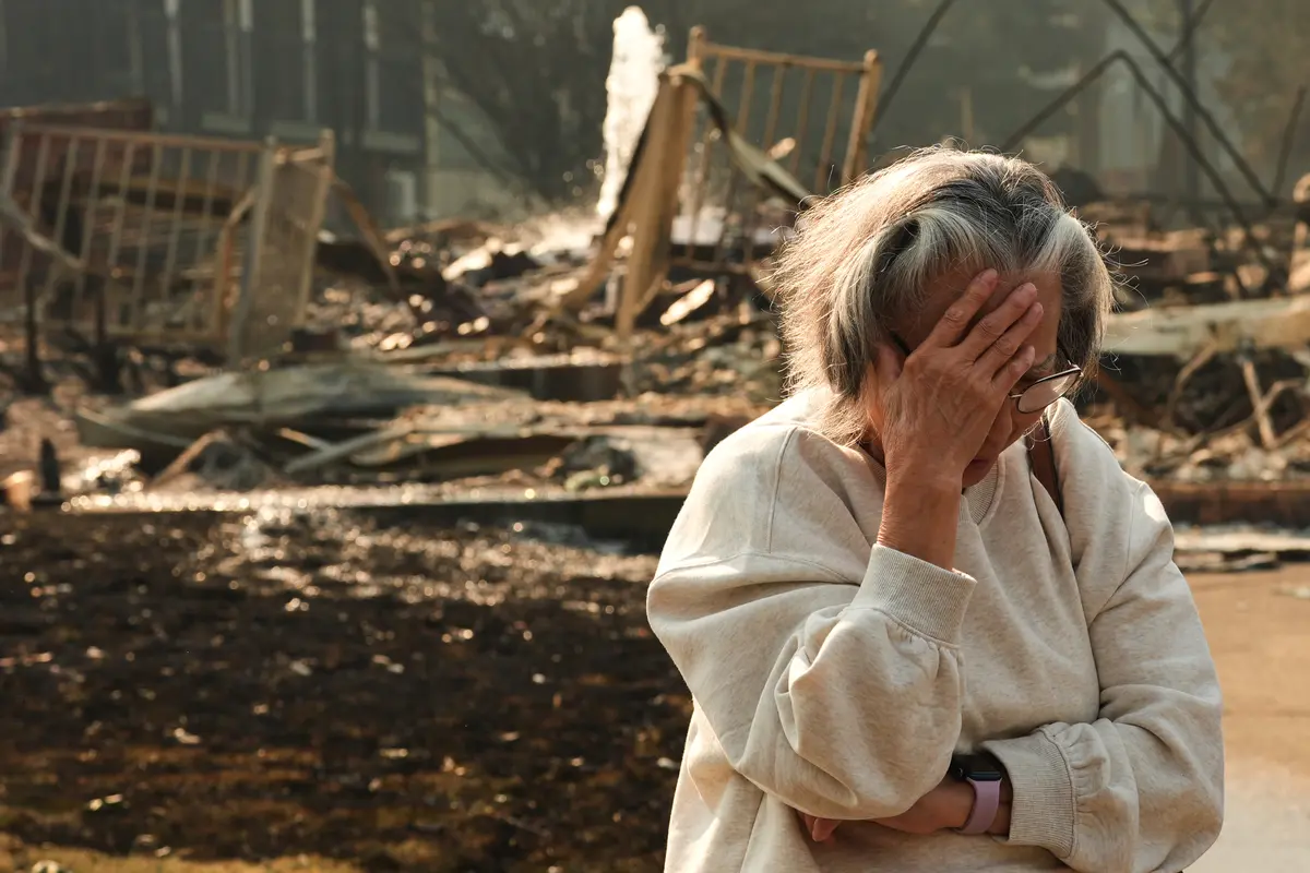 A woman reacts while talking about her neighborhood largely burning to the ground after a wildfire hit the northern part of Spokane, Wash., on Aug. 3, 2026. (Lindsey Wasson/AP Photo)