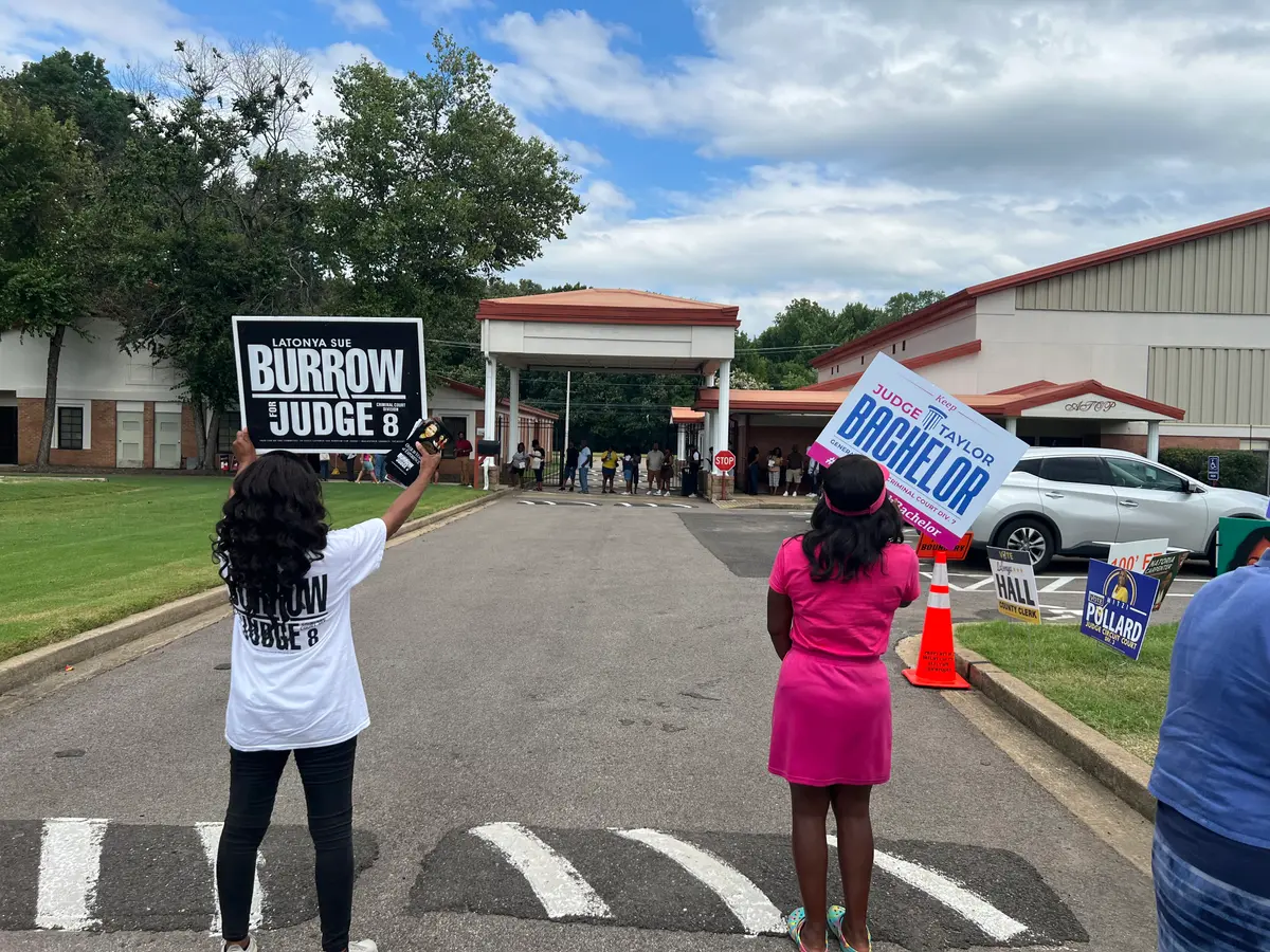 Campaigners stood in a Memphis-area parking lot touting their candidate as residents lined up to submit their early vote on Aug. 1, 2026. (Jacki Thrapp / The Epoch Times)