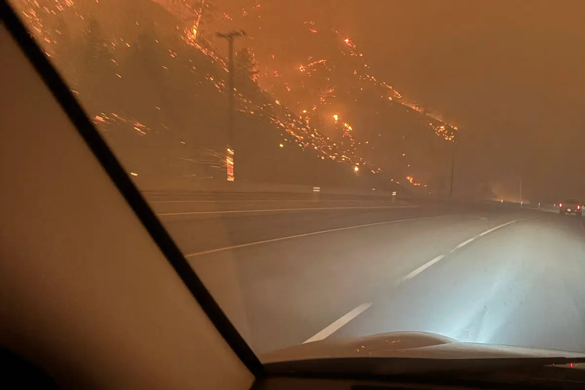 The hillside burns after midnight as residents evacuate toward Kelowna from the Bald Range wildfire along Highway 97 near Summerland, B.C., on Aug. 8, 2026. (Terry Fries/Handout via Reuters)