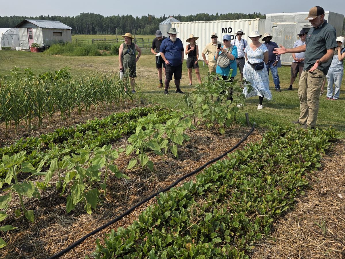 Joell Friesen (right) speaks about the various vegetables that grow on the farm, while giving a tour to a Calgary-based church group. (The Epoch Times/Jason G. Antonio)