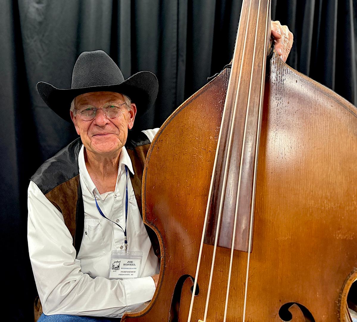 Bass player Joe Konkel of the musical group Maxwells & Joe with his instrument during the 38th annual Arizona Cowboy Poets Gathering in Prescott, Ariz., on Aug. 7, 2026. (Allan Stein/The Epoch Times)