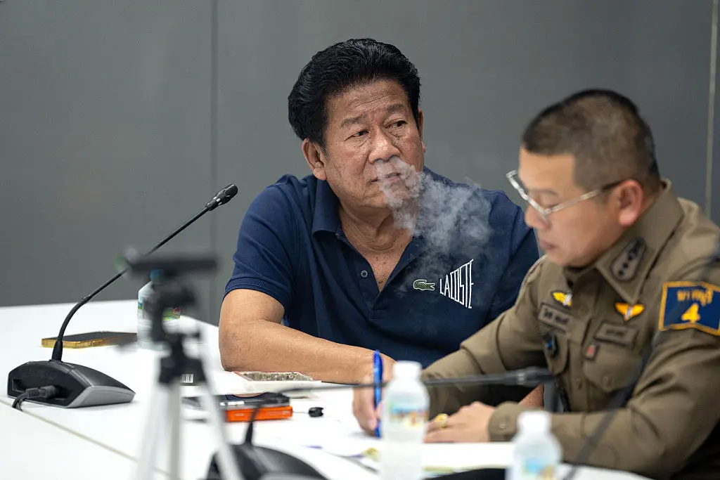 Former lawmaker Chalong Riewrang (C) exhales smoke during a press conference at a police station in Nonthaburi province, north of Bangkok, on August 10, 2026. (Arnun Chonmahatrakool/Thai News Pix/AFP via Getty Images)