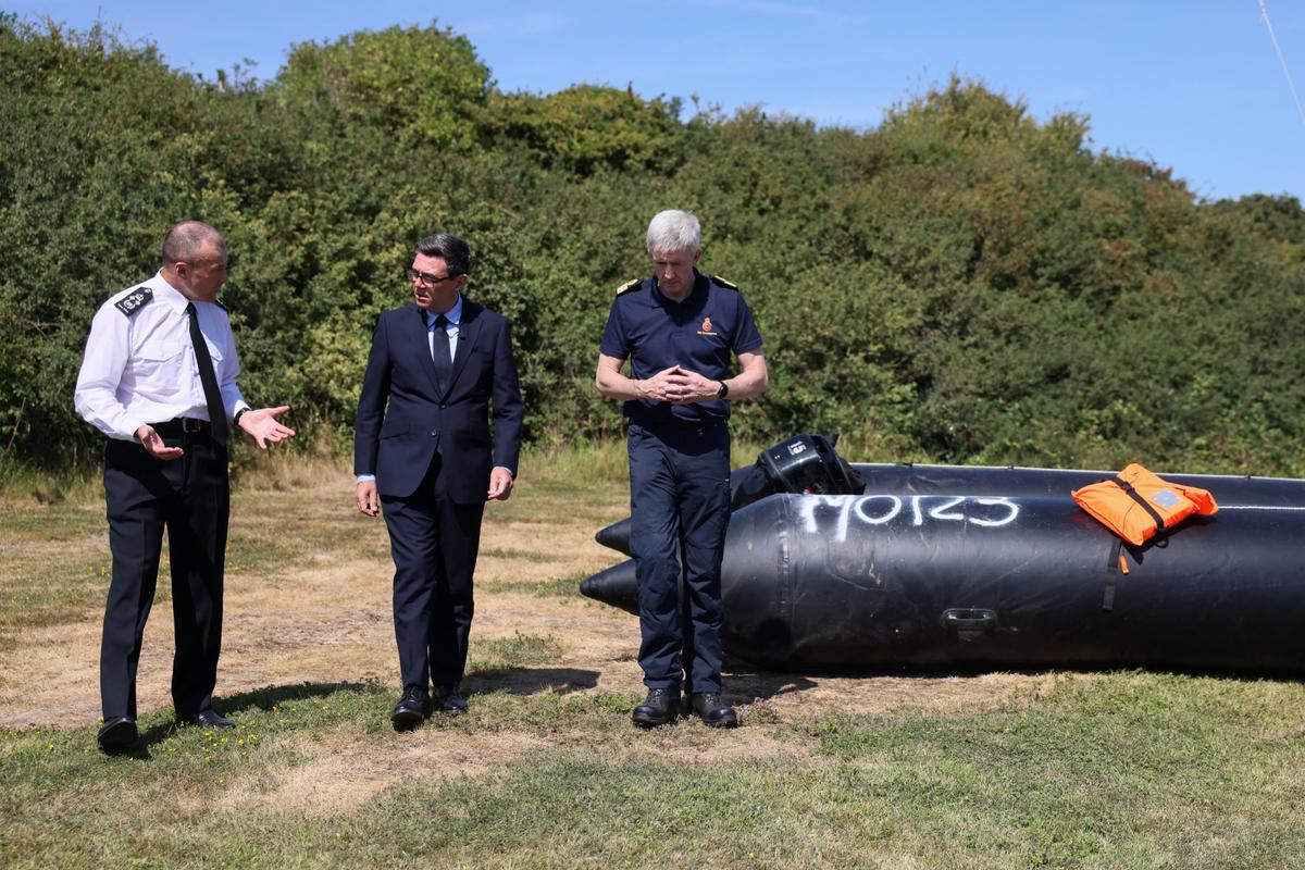 Britain's Prime Minister Andy Burnham (C) speaks with John Craig, interim chief coastguard, and Duncan Capps, border security commander (L), near a recovered small boat, which was used by migrants crossing the English Channel, during a visit to HM Coastguard Maritime Rescue Coordination Center in Dover, England, on Aug. 2, 2026. (Jack Taylor/Pool Photo via AP)