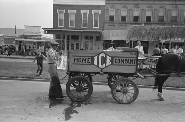 An iceman delivering ice blocks to a home, where early iceboxes were used to keep food cold and supply ice for chilled drinks. (Public Domain)