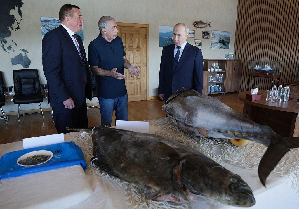 Russia's President Vladimir Putin (R) visits the Yasny fish processing factory on Iturup island, one of four islands in the contested chain known as the Kuril Islands in Russia and the Northern Territories in Japan on Aug. 13, 2026. (Gavriil Grigorov/AFP via Getty Images)